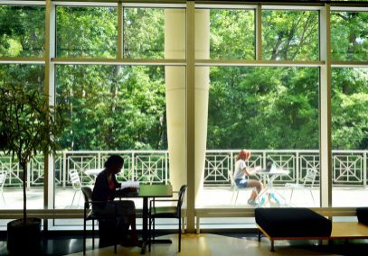 Student sitting at a table in the Stone Center lobby