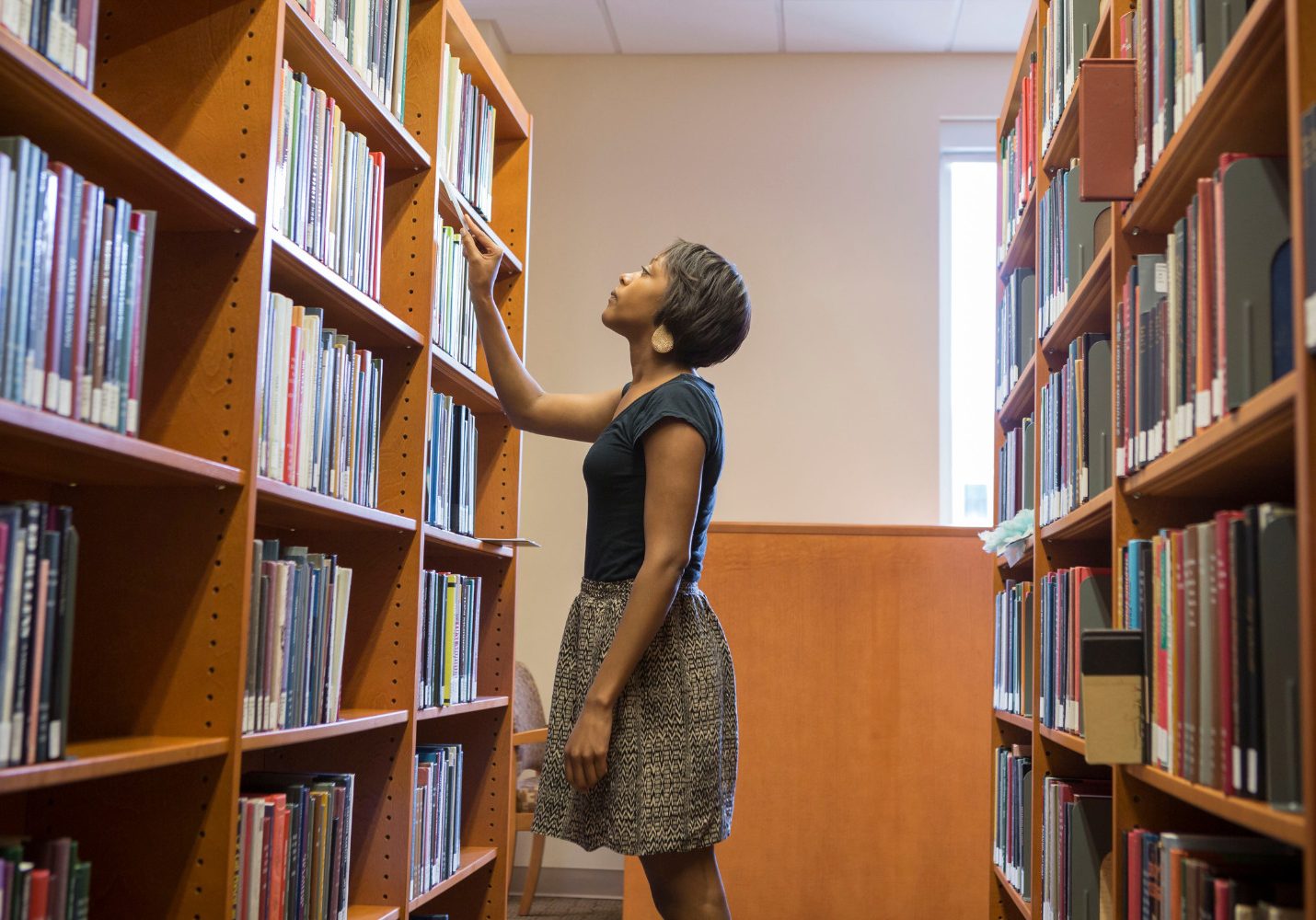 A student looks through the shelves for a specific book
